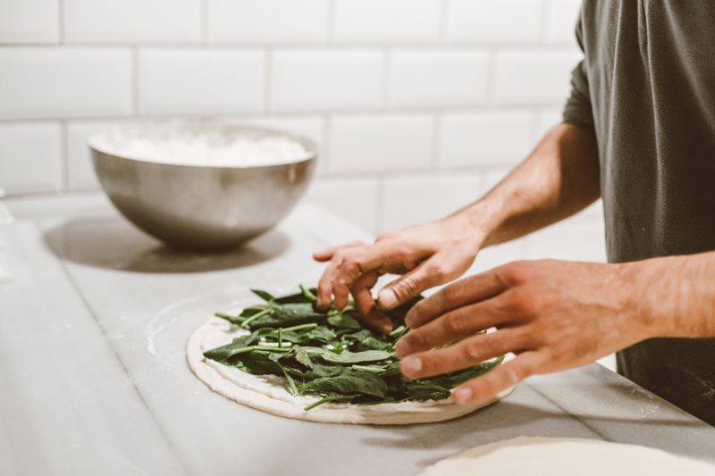 Fresh pizza being prepared at deweys kitchen